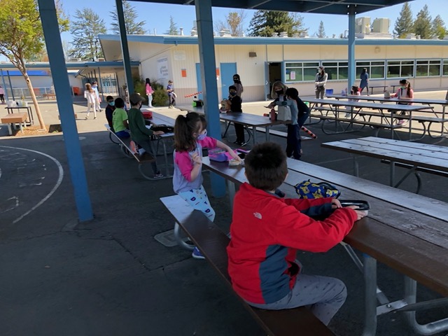 Tables pushed together to make double tables, three kids per side