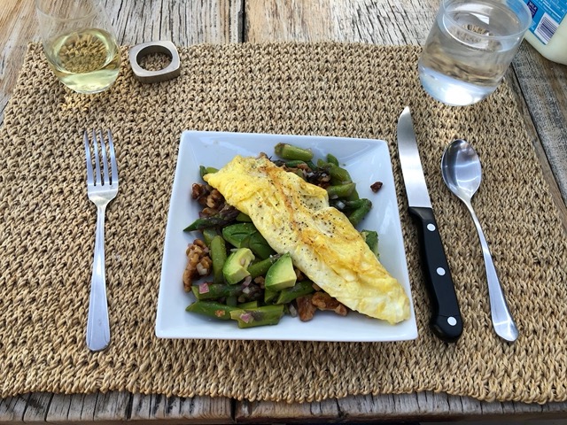 Omelet on spring salad with asparagus and walnuts