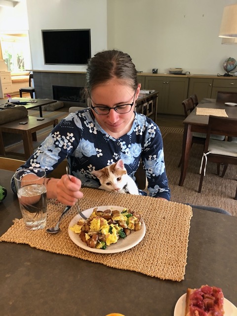 Lela with 'school lunch' of a big scramble, with cat