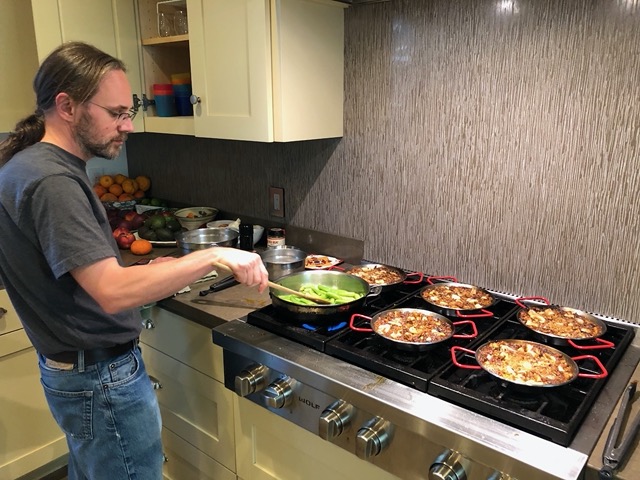 Mike making sugar snap peas while I manage the paellas
