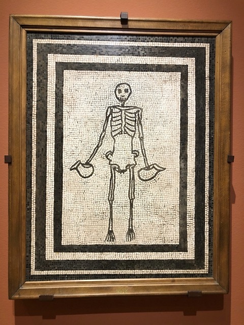 Mosaic of a skeleton holding two distinctively-shaped wine jugs