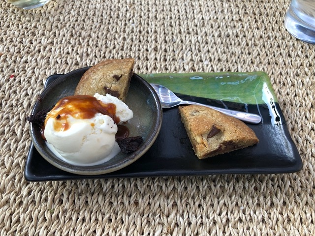 Summer dessert of homemade vanilla ice cream, caramel sauce, warm choc chip cookie