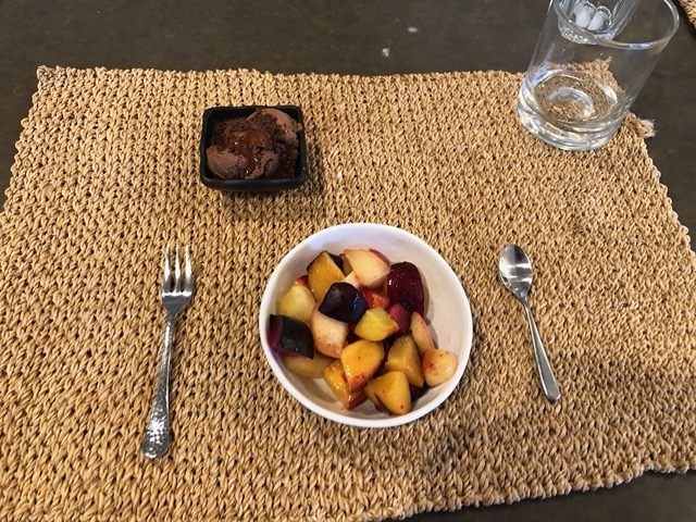 Dessert of fresh stonefruit, chocolate ice cream, and chocolate crumbles