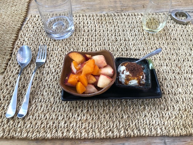 Summer dessert of stonefruit, vanilla ice cream with caramel sauce and chocolate crumble