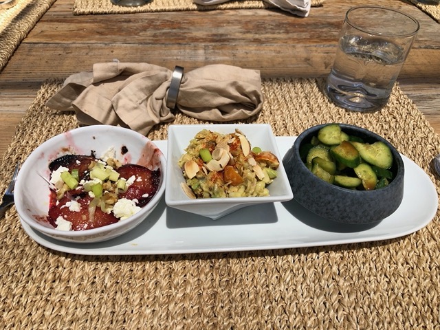 Grilled plums, small salad with nuts, and cucumber salad