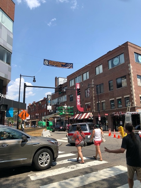 Busy street, with 'participatory budgeting' banner, very New England participatory government