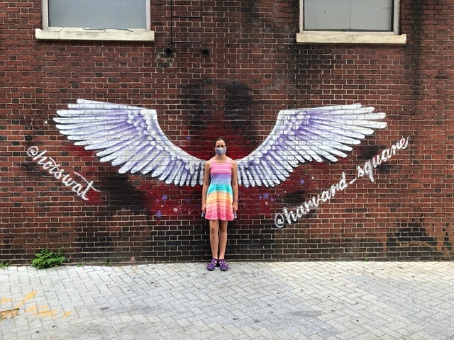 Ellie with wings painted on wall for pictures