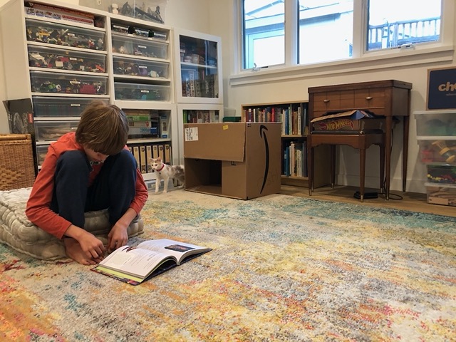 Everyone is sitting on the floor, reading