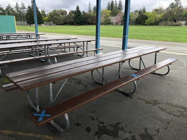 Blue X's in tape mark where kids can sit for lunch, 6 feet apart & nobody across from them