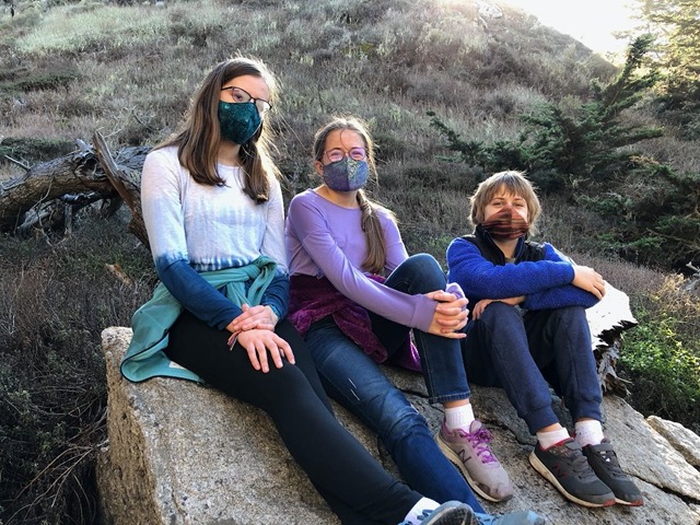 The kids on a rock, with masks